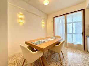 ein Esszimmer mit einem Holztisch und Stühlen in der Unterkunft Falz 1 Family Apartments - Carraro Immobiliare Jesolo in Lido di Jesolo + 7 Fotos