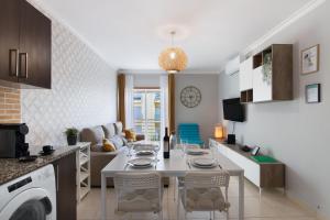 Una cocina y una sala de estar con una mesa y sillas blancas. en Apartamento T2 Rio E Mar, en Vila Real de Santo António