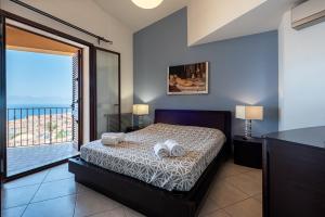 a bedroom with a bed with a view of the ocean at Moderno Appartamento in Cefalù