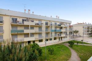 Un edificio de apartamentos con balcones y una calle. en Apartamento T2 Rio E Mar, en Vila Real de Santo António