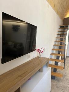 a flat screen tv on a wall next to a staircase at Maison De Mammà in Altamura +16 photos