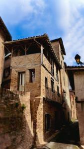 un vecchio edificio in mattoni con un tetto su una strada di La Bohème Saint Michel by Art&Suites a Gaillac