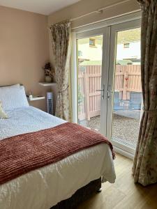 a bedroom with a bed and a sliding glass door at Stepping Stone in Fort William