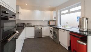 a kitchen with a washer and dryer in it at Entire Manor Grove Blackpool in Blackpool