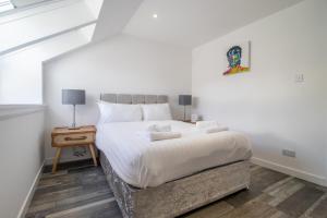 ペイズリーにあるAbbey Houseのベッドルーム(白い大型ベッド、ナイトスタンド付)