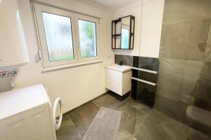 a bathroom with a shower and a sink and a mirror at 22A Große Wohnung mit Terrasse und Smart TV in Korb