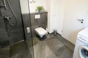 a bathroom with a toilet and a glass shower at 22A Große Wohnung mit Terrasse und Smart TV in Korb +1 photo