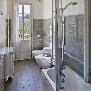 La salle de bains est pourvue de 2 toilettes, d'un lavabo et d'une baignoire. dans l'établissement M Club De Luxe B&B, à Ravenne