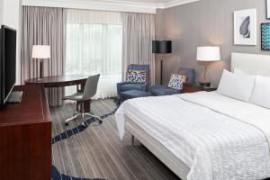 a hotel room with a bed and a desk and a computer at Le Meridien Arlington in Arlington
