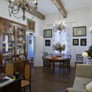 una sala da pranzo con tavolo, sedie e lampadario pendente di M Club De Luxe B&B a Ravenna