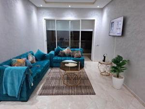 布兹尼盖Appartement vue panoramique的客厅里有一张蓝色的沙发和一张桌子 更多3张照片