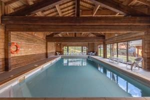 an indoor pool in a house with wooden walls and ceilings at Chalet du Bief , Morillon 4-6 pers in Morillon