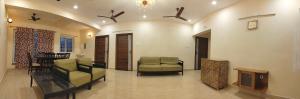 a living room with two chairs and a tv at SaiNivas Satyam in Chennai