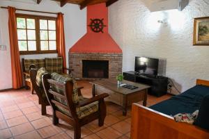 a living room with a fireplace and a tv at El Descubrimiento Resort Club in Guazuvira
