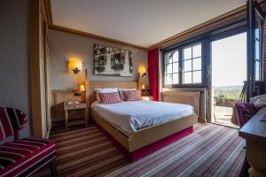 a hotel room with a bed and a large window at Hôtel Arnold in Itterswiller