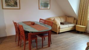 ein Wohnzimmer mit einem Tisch, Stühlen und einem Sofa in der Unterkunft Residenz Zum Kronprinzen in Bad Saarow