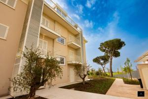 an apartment building with trees in front of it at Bed&BikeRome GALERIA ANTICA in Santa Maria di Galeria