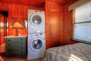 a bedroom with a washing machine and a washer at Averette Cottage by Carolina Beach Realty in Carolina Beach