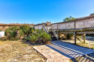 a wooden walkway with a bench and a bridge at Averette Cottage by Carolina Beach Realty in Carolina Beach