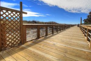 a wooden boardwalk over the sand at the beach at Averette Cottage by Carolina Beach Realty in Carolina Beach