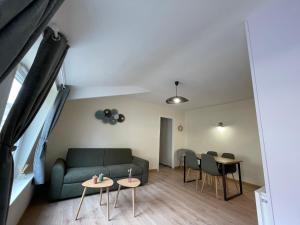 a living room with a couch and chairs and tables at L'olive - cuisine équipée, centre ville, fibre in Ardres
