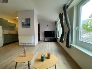a living room with two tables and a large window at L'olive - cuisine équipée, centre ville, fibre in Ardres