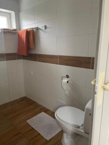 a bathroom with a toilet and towels on the wall at 3 izbovy RD - bungalow in Bernolákovo