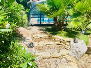 a garden with a stone path and a glass house at Studio chic & champêtre in Aussonne