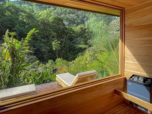 a window in a room with a view of a forest at Charming Cosy Chirripó Mountain Riverfront Cottage in Canaán