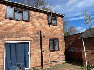a brick building with a door and a window at Award-Winning Four Bedrooms House, Parking, WiFi By Derby Short Term Rental Short Lets & Serviced Accommodation Derby in Derby