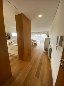 a kitchen and a living room with a wooden floor at T2 Dunas Esposende in Esposende