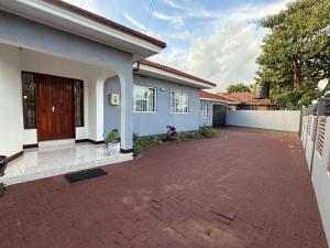 a house with a brick driveway in front of it at Logic stays 3 bedroom Arusha, Njiro in Arusha