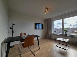 a dining room with a table and chairs and a large window at Centralt och modernt in Stockholm
