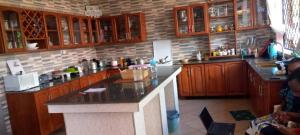 eine Küche mit Holzschränken und einer Arbeitsplatte in der Unterkunft Sauda Homestay in Arusha