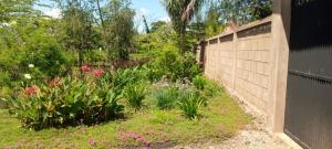 einen Garten mit Blumen und einem Zaun in der Unterkunft Sauda Homestay in Arusha + 9 Fotos
