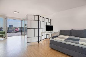 a bedroom with a bed and a desk with a television at Messe-Appartement Ihmeblick in Hannover +17 photos