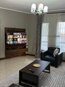 a living room with a couch and a tv at Elly's Three bedroom Home in Arusha +15 photos