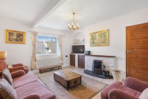 a living room with a couch and a fireplace at Spindlestone Cottage - North East Escapes in Bamburgh