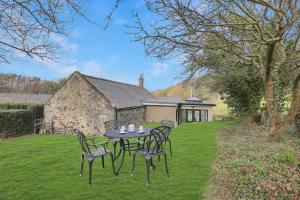 a table and chairs in the yard of a house at Spindlestone Cottage - North East Escapes in Bamburgh