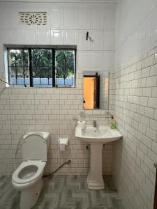 a white bathroom with a toilet and a sink at Logic stays 3 bedroom Arusha, Njiro in Arusha +15 photos