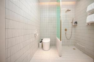 a white bathroom with a toilet and a shower at EUPHORIA丨Quiet Garden Quiet Designer Garden Hotel丨Datang Never Sleeps City Big Wild Goose Pagoda Subway Station Branch丨Near the scenic area in Xi'an