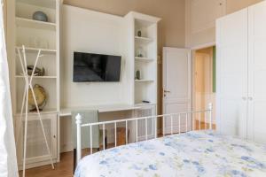 a bedroom with a bed and a tv and shelves at Casa Desy in Forte dei Marmi