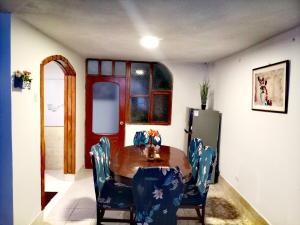 a dining room with a wooden table and blue chairs at El Descanso in Cusco