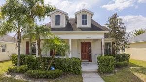 a house with palm trees in front of it at Cozy 4Bd Home Pool & Hot Tub at Trafalgar Resort in Kissimmee