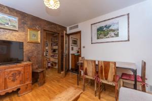 a living room with a television and a table and chairs at Chalet Baranci in Pozza di Fassa