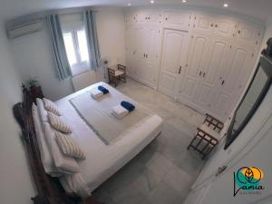 a bedroom with a large bed with white sheets and pillows at Chalets en Sancti Petri in Novo Sancti Petri