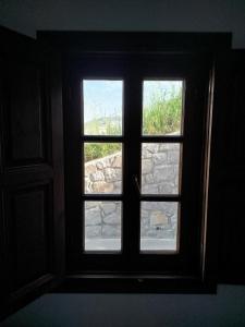 a window in a room with a stone wall at kominoshouses in Skala
