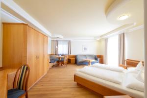 Habitación hospitalaria con 2 camas, mesa y sillas en Garni Luziafeld Hof, en Appiano sulla Strada del Vino