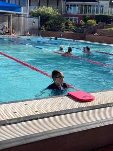 a man laying on a surfboard in a swimming pool at Garden View Entire Self Contained Guesthouse in Engadine