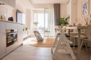 a kitchen and living room with a table and chairs at Vibra Tahiti Prestige in Lido di Jesolo